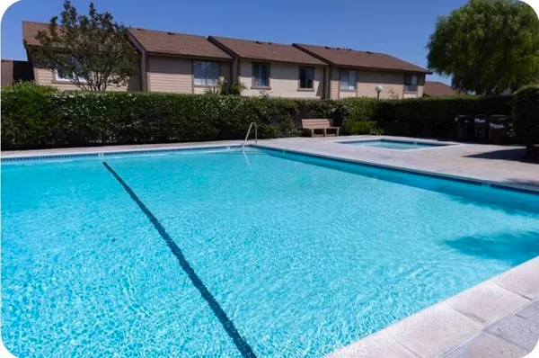 a living room with chairs and wooden floor