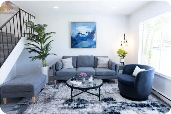 a living room with furniture potted plant and a window