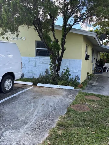 a front view of a house with a garden and parking space