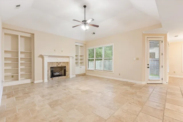 a view of an empty room with a fireplace and a window