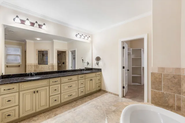 a spacious bathroom with a granite countertop tub sink and mirror