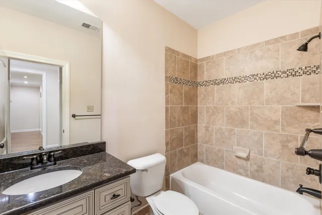 a bathroom with a granite countertop sink toilet a mirror and shower
