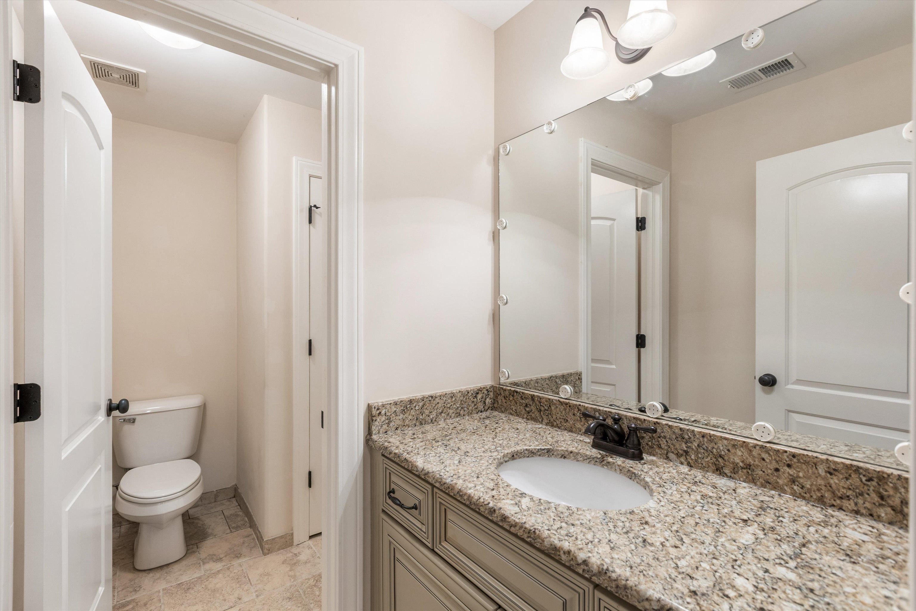 1651 Dehaig Lane Collierville, TN 38017 - Photo 26 of 36 a bathroom with a granite countertop sink a mirror and a toilet