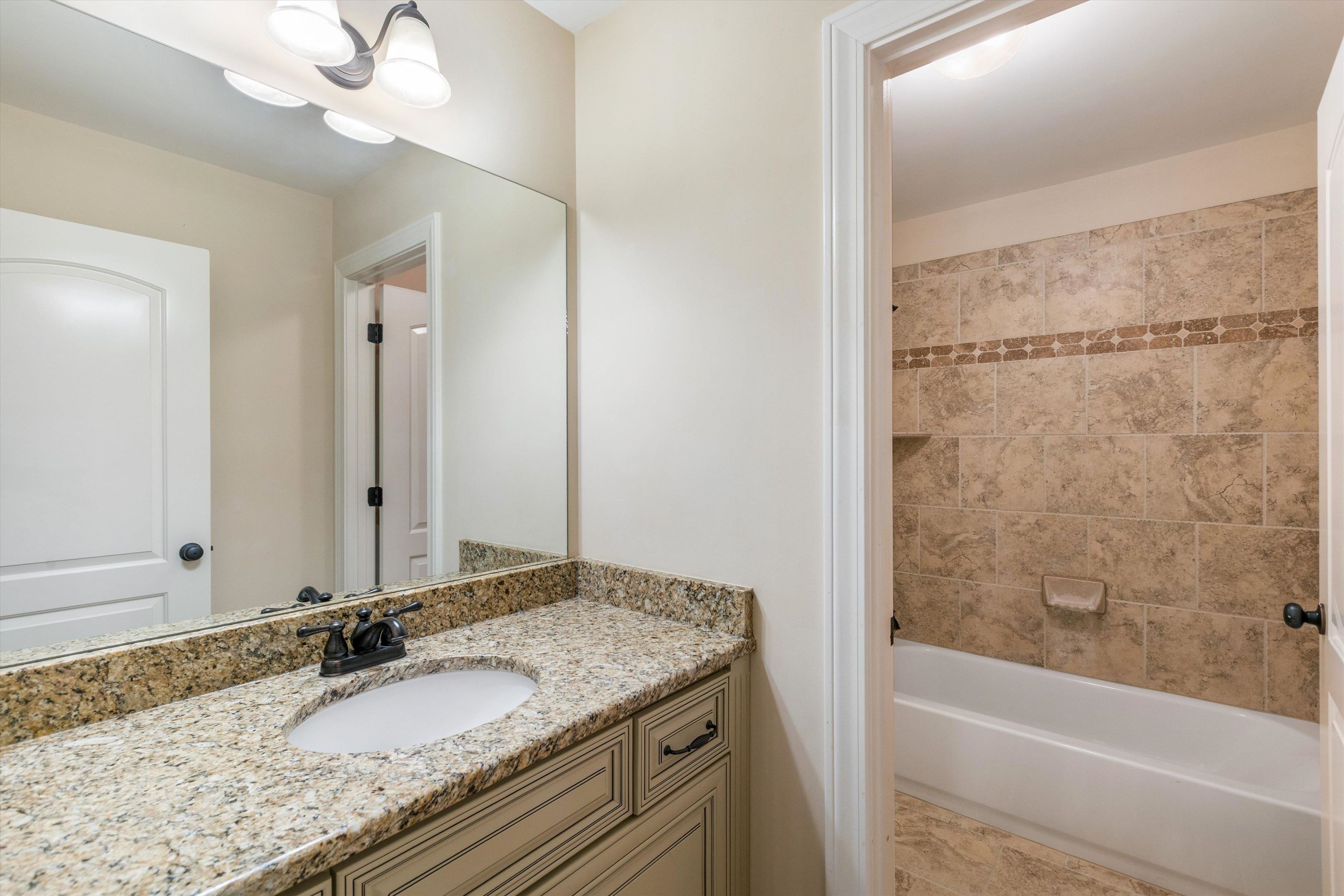 1651 Dehaig Lane Collierville, TN 38017 - Photo 28 of 36 a bathroom with a granite countertop sink and a mirror