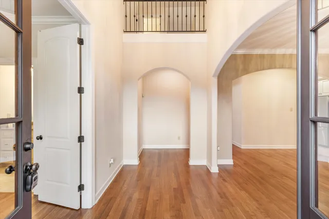 a view of a hallway with wooden floor and staircase