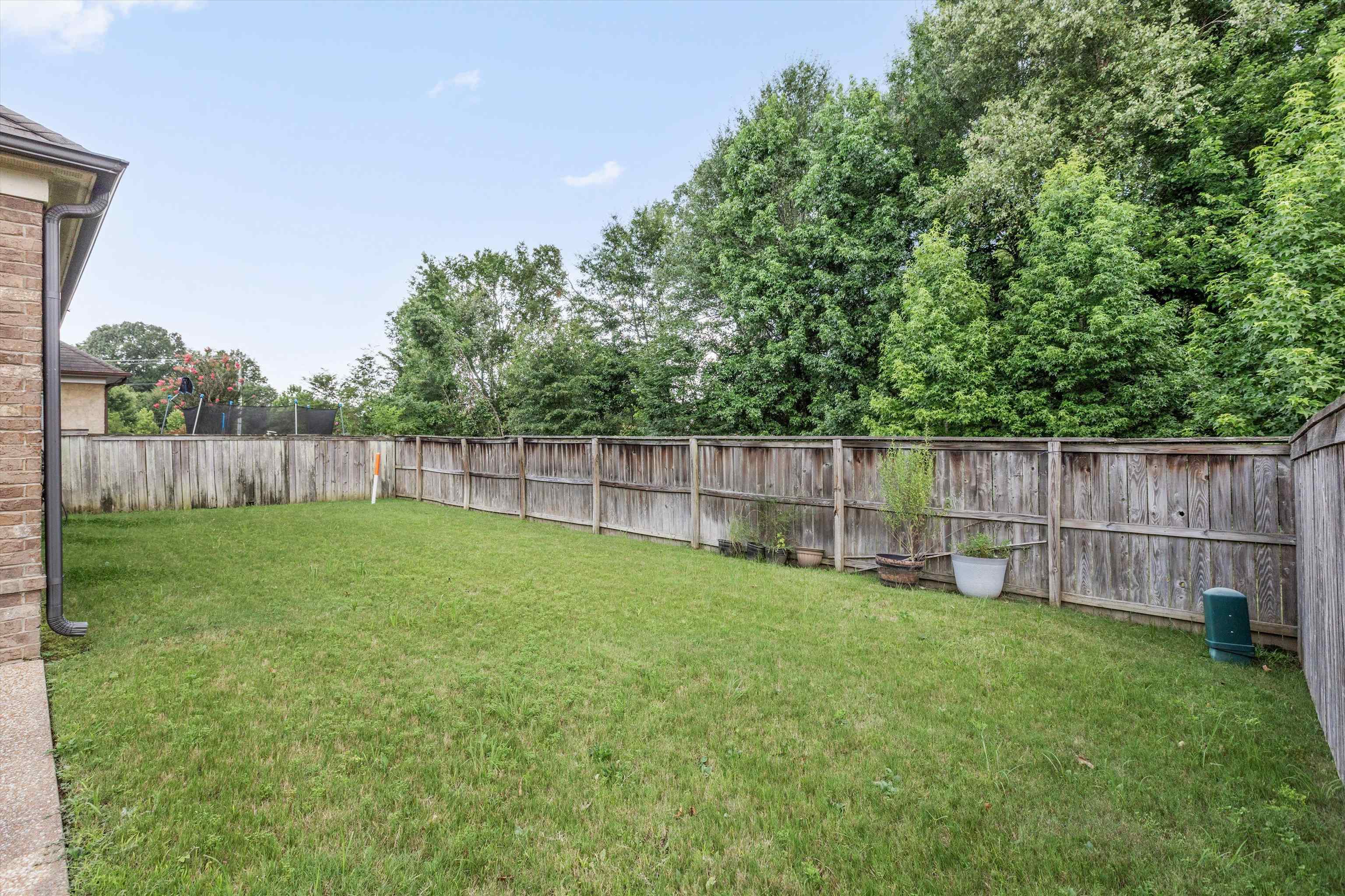 1651 Dehaig Lane Collierville, TN 38017 - Photo 34 of 36 a view of a backyard with a small cabin and wooden fence