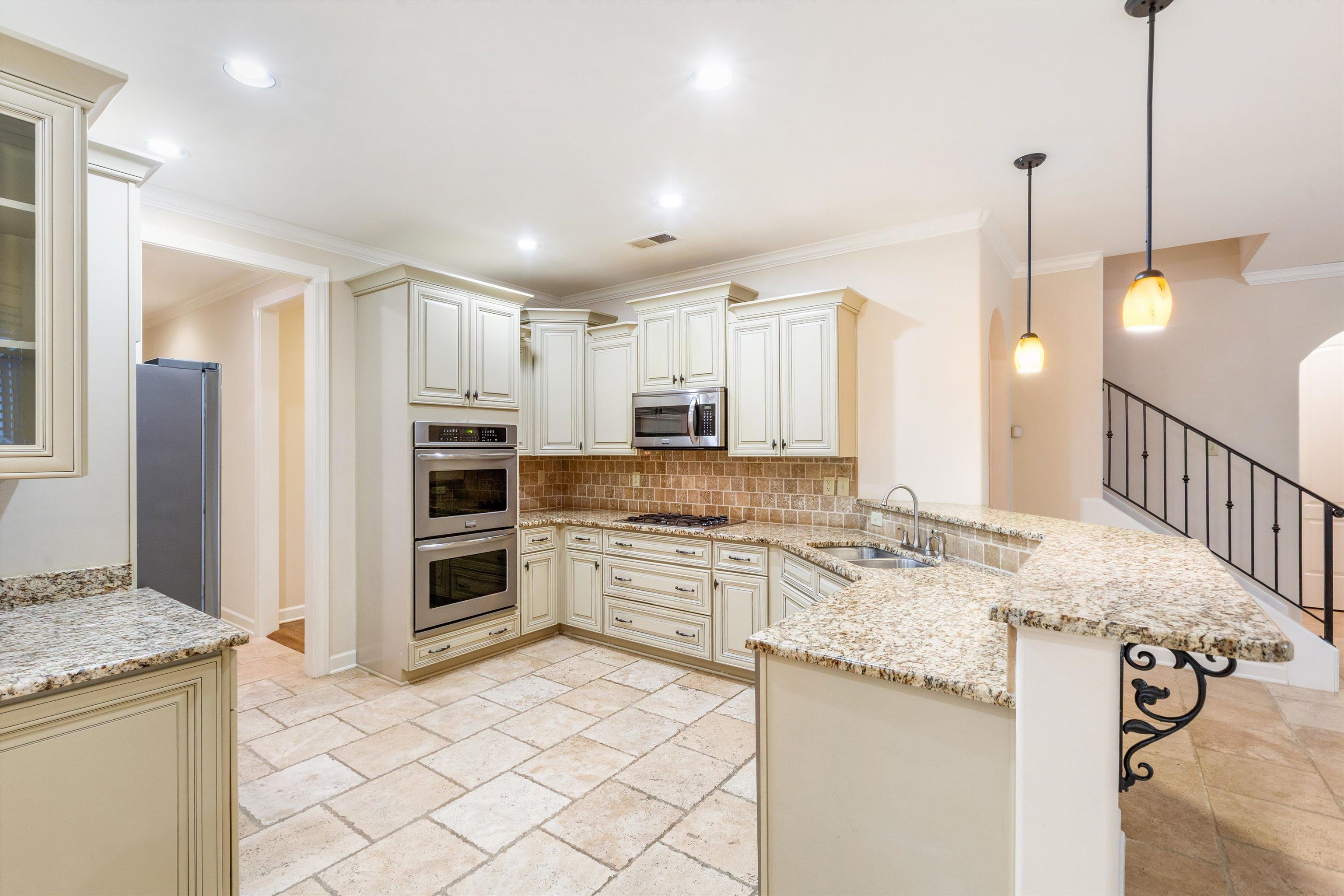 1651 Dehaig Lane Collierville, TN 38017 - Photo 6 of 36 a kitchen with stainless steel appliances kitchen island granite countertop a stove and a sink