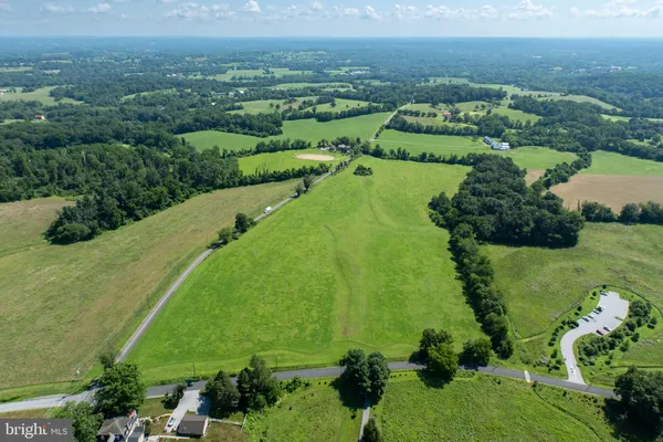 an aerial view of green landscape with trees houses and lake view