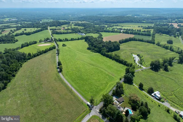an aerial view of a houses with a yard and lake view