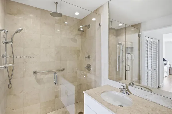 a bathroom with a granite countertop shower sink and mirror