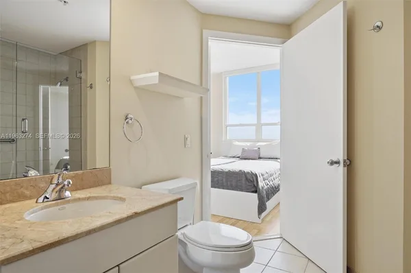 a bathroom with a granite countertop sink a toilet and shower