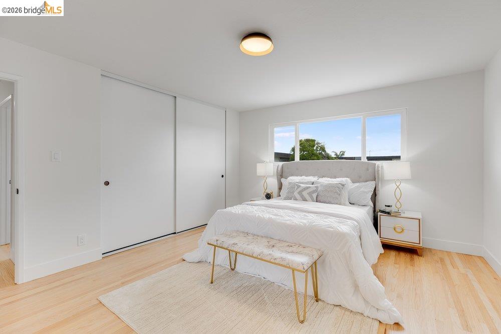 1298 Ribbon Street Foster City, CA 94404 - Photo 61 of 86 Bright bedroom featuring light wood-finish flooring, a large window, a ceiling-mounted light fixture, and white sliding closet doors