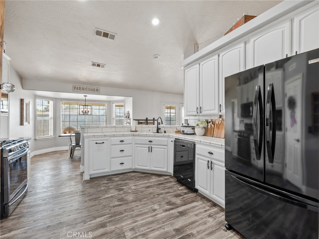 6370 Fremontia Road Hesperia, CA 92344 - Photo 26 of 62 a kitchen with white cabinets and stainless steel appliances