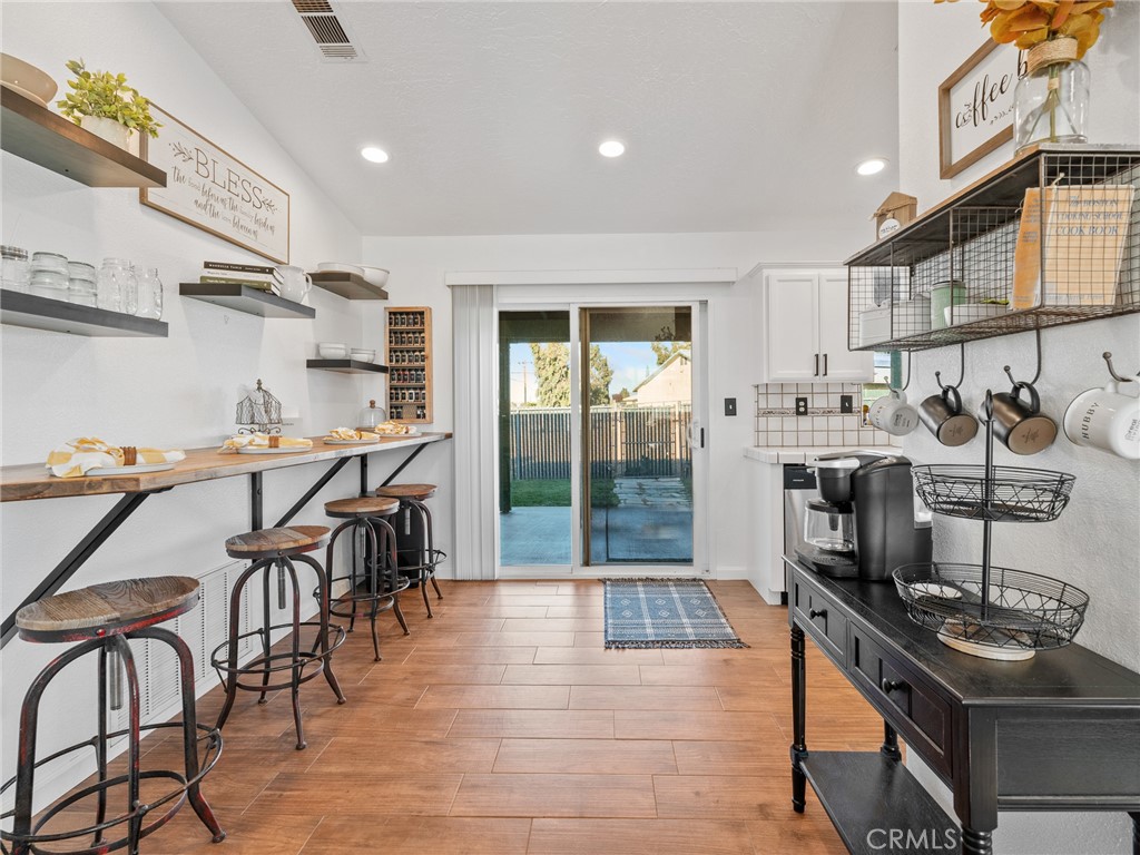 6370 Fremontia Road Hesperia, CA 92344 - Photo 53 of 62 a kitchen with stainless steel appliances granite countertop a stove top oven a sink a dining table and chairs with wooden floor