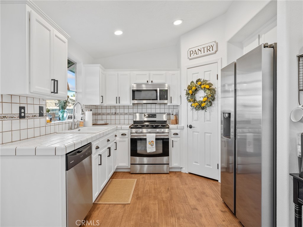 6370 Fremontia Road Hesperia, CA 92344 - Photo 55 of 62 a kitchen with stainless steel appliances granite countertop a refrigerator and a stove top oven