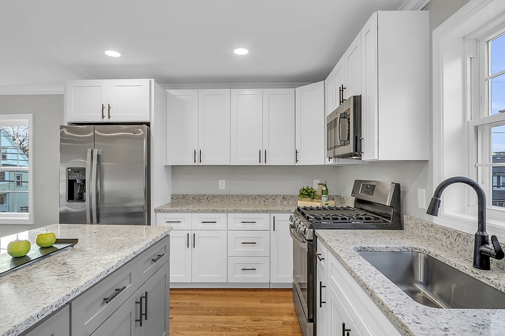 30 Broadway, Unit A Lynn, MA 01904 - Photo 11 of 34 a kitchen with stainless steel appliances granite countertop a sink a stove a refrigerator a microwave a counter space and cabinets