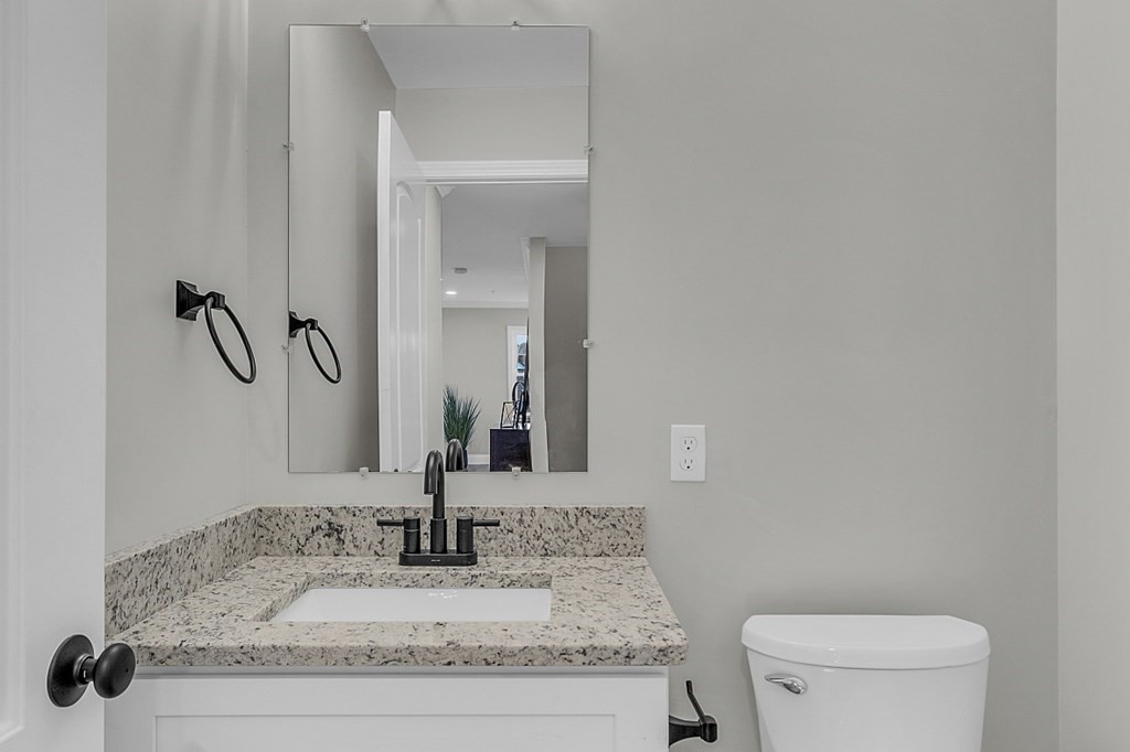 30 Broadway, Unit A Lynn, MA 01904 - Photo 19 of 34 a bathroom with a granite countertop sink a toilet and mirror