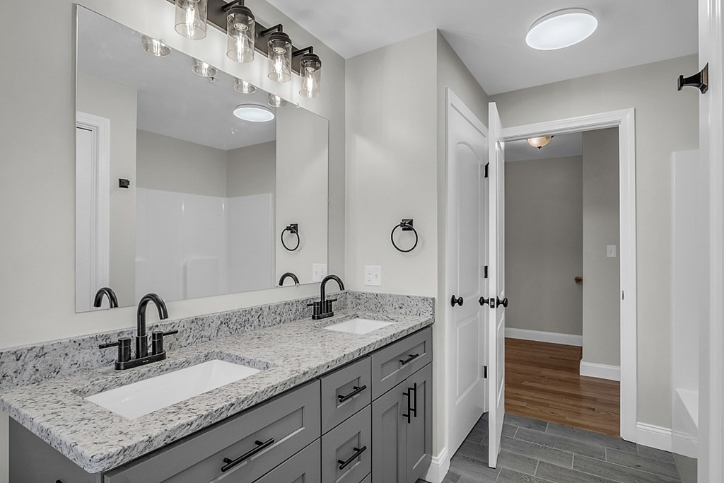 30 Broadway, Unit A Lynn, MA 01904 - Photo 28 of 34 a bathroom with a granite countertop double vanity sink and mirror