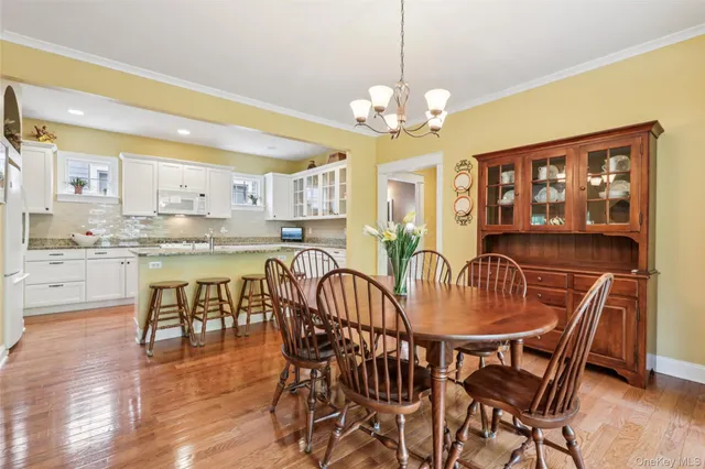 a view of a dining room with furniture a chandelier and wooden floor