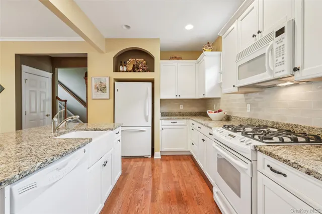 a kitchen with granite countertop cabinets stainless steel appliances and a wooden floor