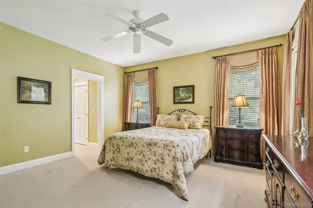 a bedroom with a large bed a chandelier and windows