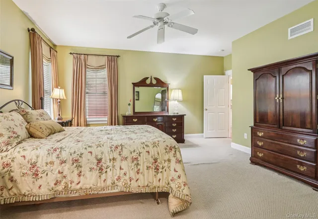 a bedroom with a bed and dresser with mirror