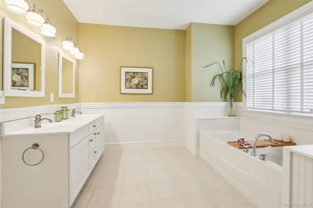 a bathroom with a tub sink and mirror