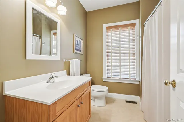 a bathroom with a sink a toilet and a mirror