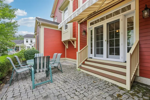 a front view of a house with a chairs and table chair