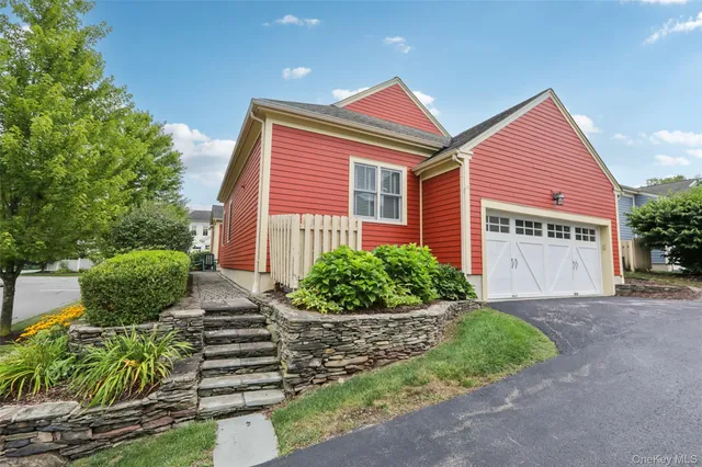 a front view of a house with a yard and potted plants