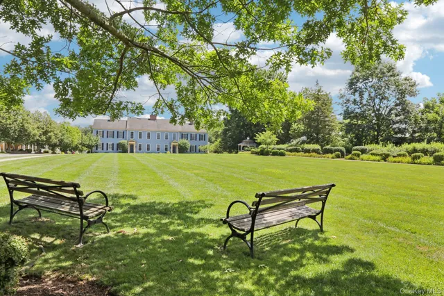 a view of a bench in the garden near a lake