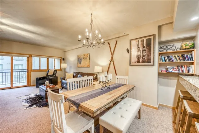 a living room with furniture a chandelier and a dining table with wooden floor