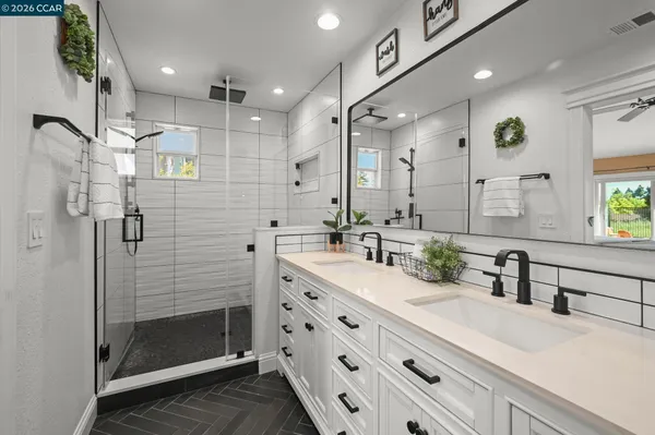 a bathroom with a double vanity sink mirror and shower