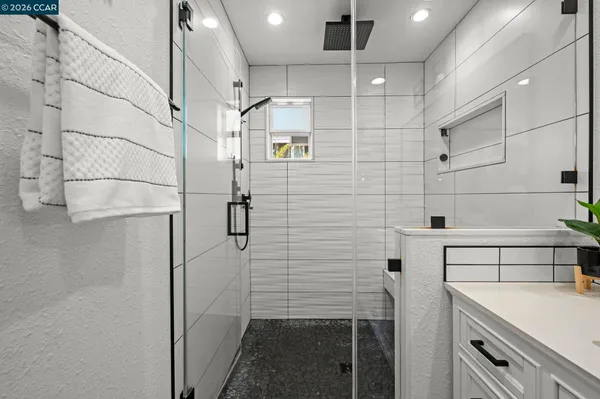a bathroom with a sink shower and a mirror