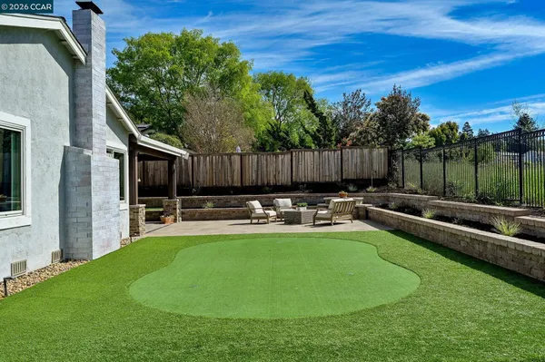 a view of a backyard with couches plants and large tree