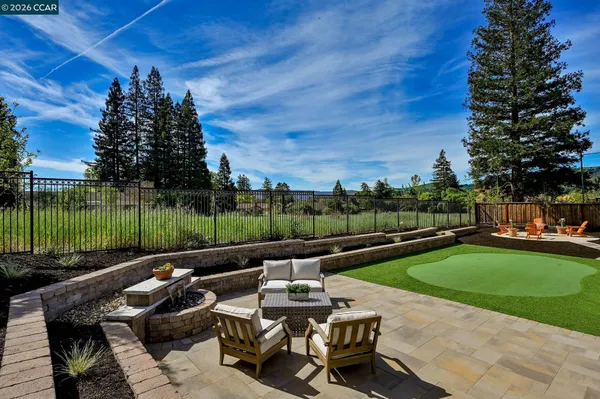 a view of a patio with swimming pool and table and chairs with wooden fence