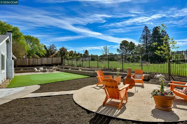 a view of a patio with table and chairs potted plants with wooden fence