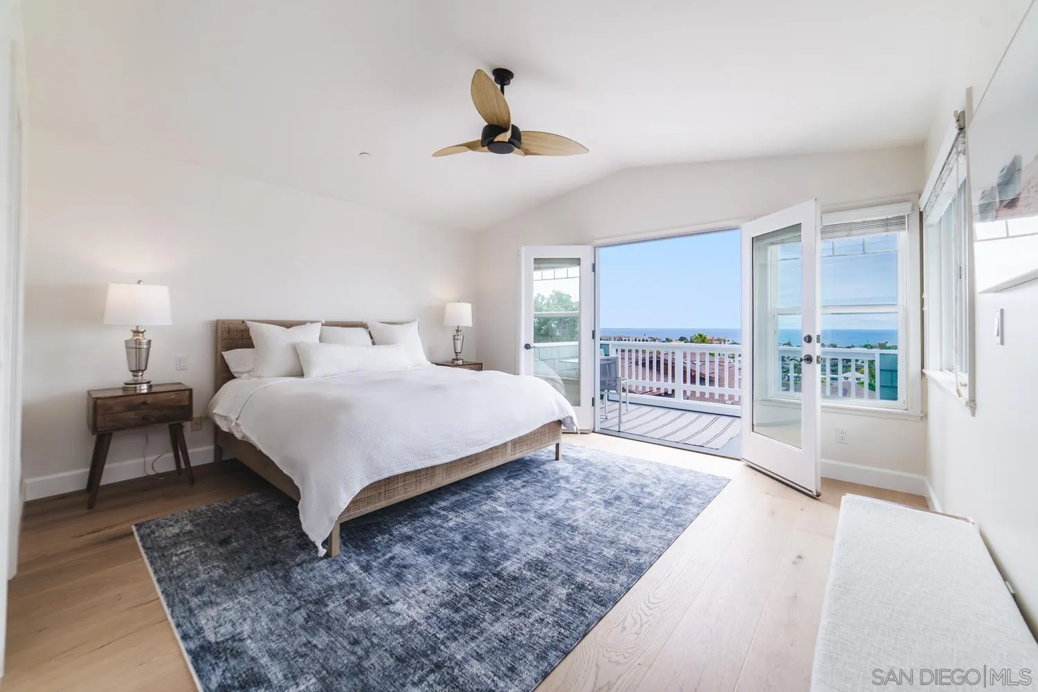 742 Cornish Drive Encinitas, CA 92024 - Photo 11 of 30 a bedroom with a large bed a chandelier and windows