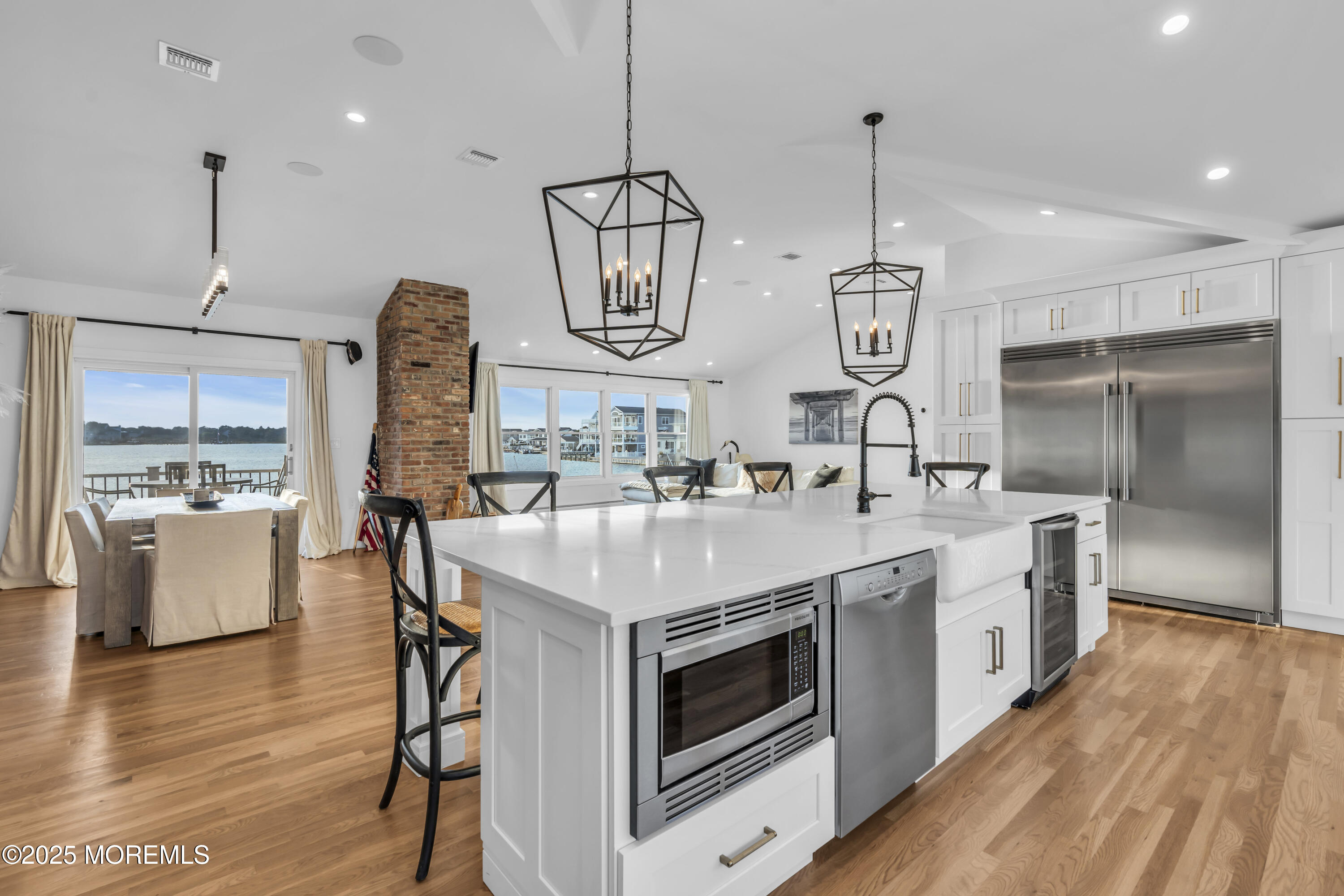 8 Channel Road Toms River, NJ 08753 - Photo 18 of 60 a kitchen with stainless steel appliances a stove a sink island a refrigerator and a dining table with wooden floor