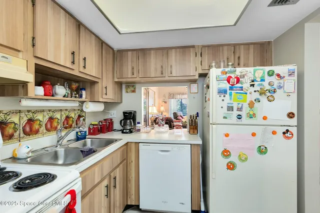 a kitchen with stainless steel appliances a sink a refrigerator and a window
