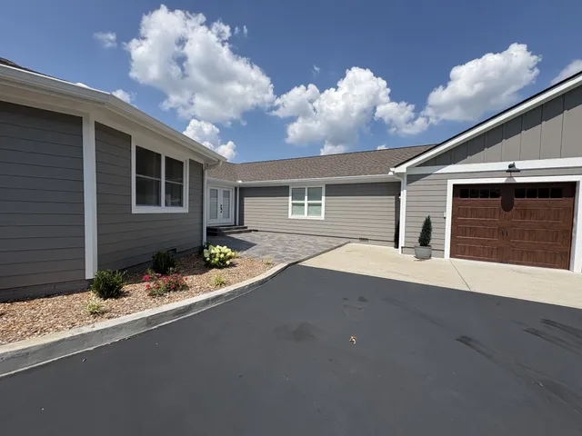 a front view of house with yard and trees in the background