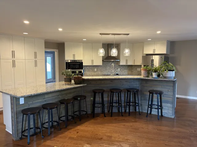 a kitchen with stainless steel appliances granite countertop a kitchen island a stove and a sink