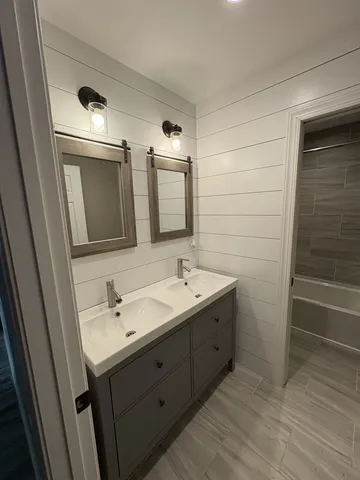 a bathroom with a double vanity sink and mirror