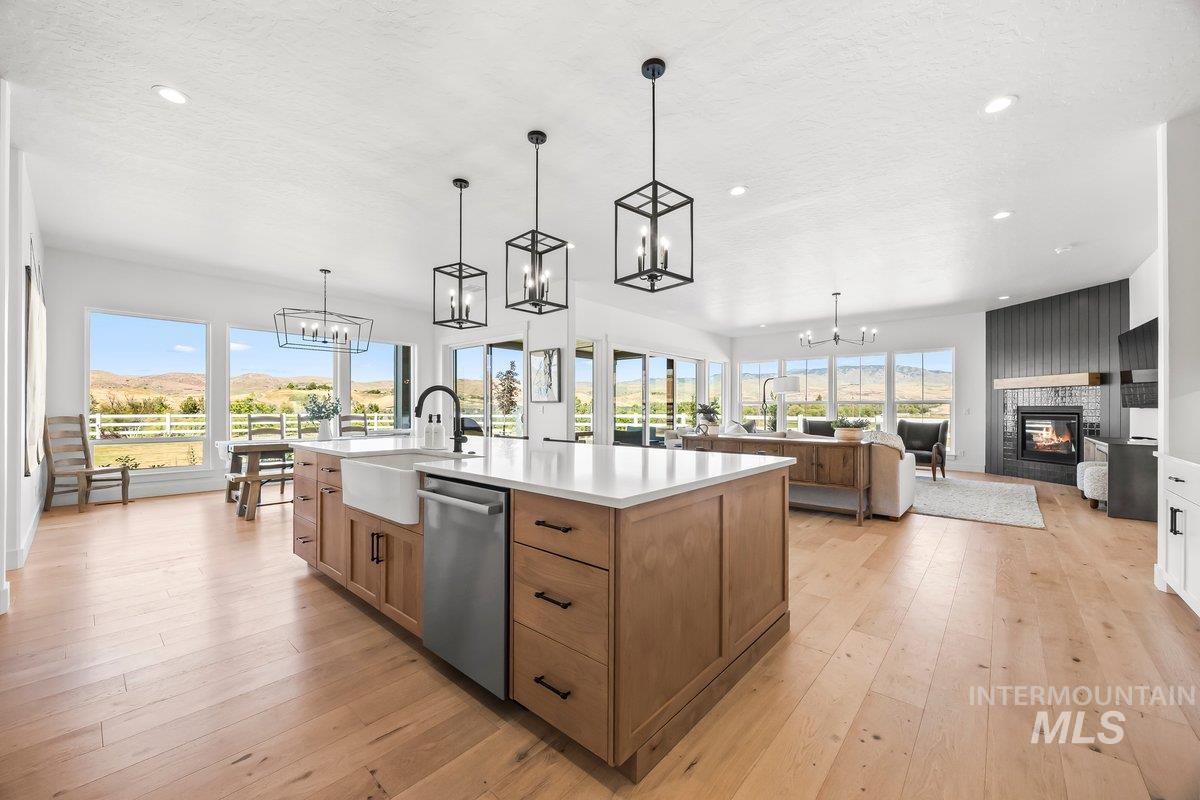13746 North Ruffed Grouse Way Boise, ID 83714 - Photo 10 of 43 Kitchen featuring dishwasher, a chandelier, a fireplace, light countertops, and recessed lighting