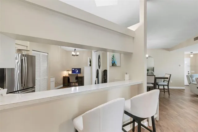 a living room with furniture and a dining table with wooden floor