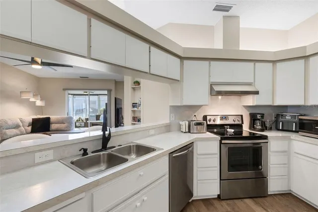 a kitchen with granite countertop a sink stainless steel appliances and cabinets