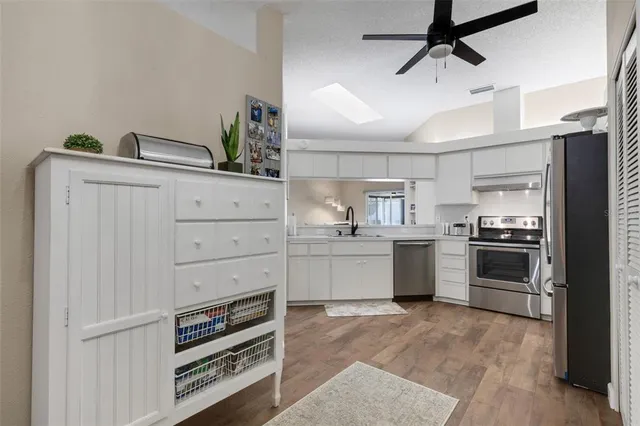 a kitchen with a refrigerator sink and cabinets