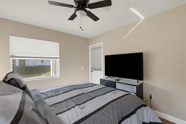 a bedroom with a bed and a flat tv screen on a dresser