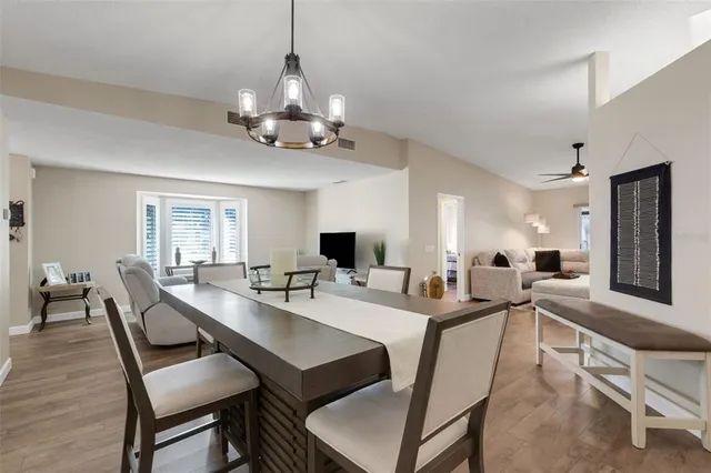 a view of a dining room and livingroom with furniture wooden floor a chandelier