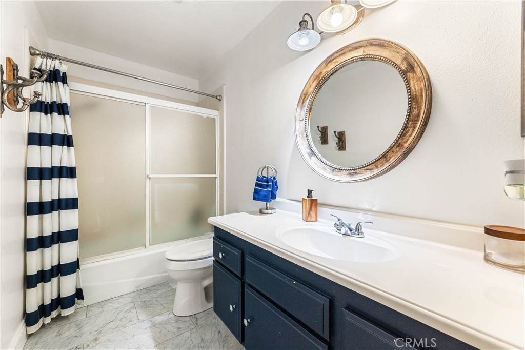18146 Oxnard Street, Unit 48 Tarzana, CA 91356 - Photo 28 of 52 a bathroom with a sink a toilet and a mirror
